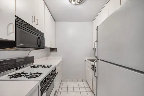 a kitchen with granite countertop a stove and a microwave