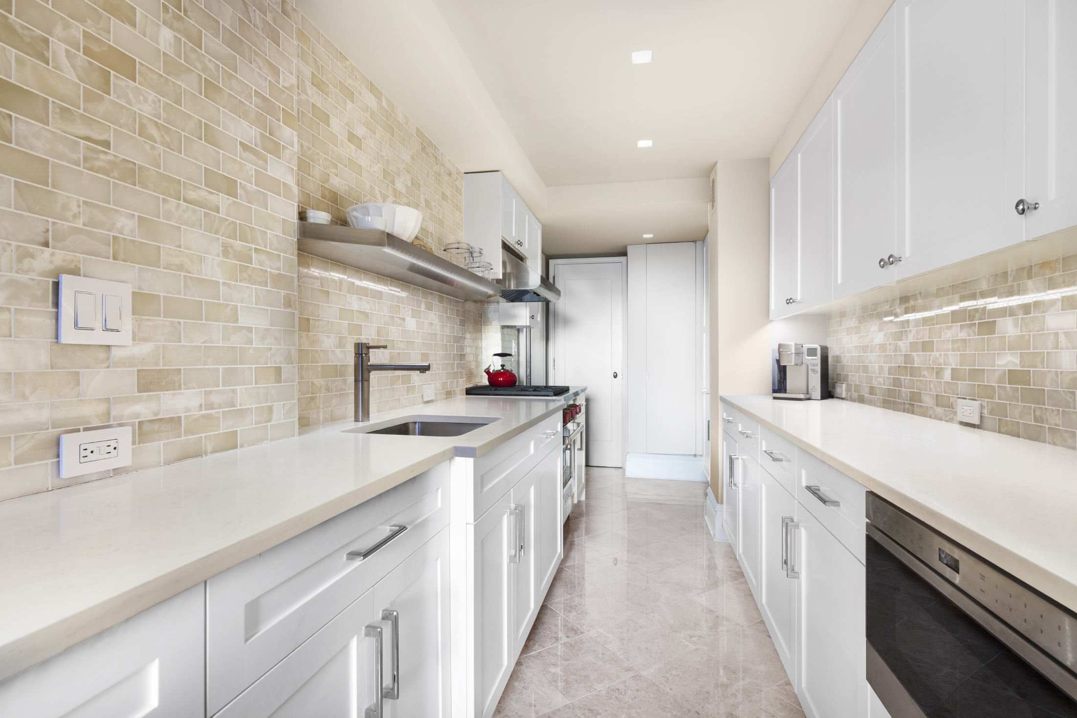11 5th Avenue, Unit 15H Manhattan, NY 10003 - Photo 3 of 10 a kitchen with a sink stove and cabinets