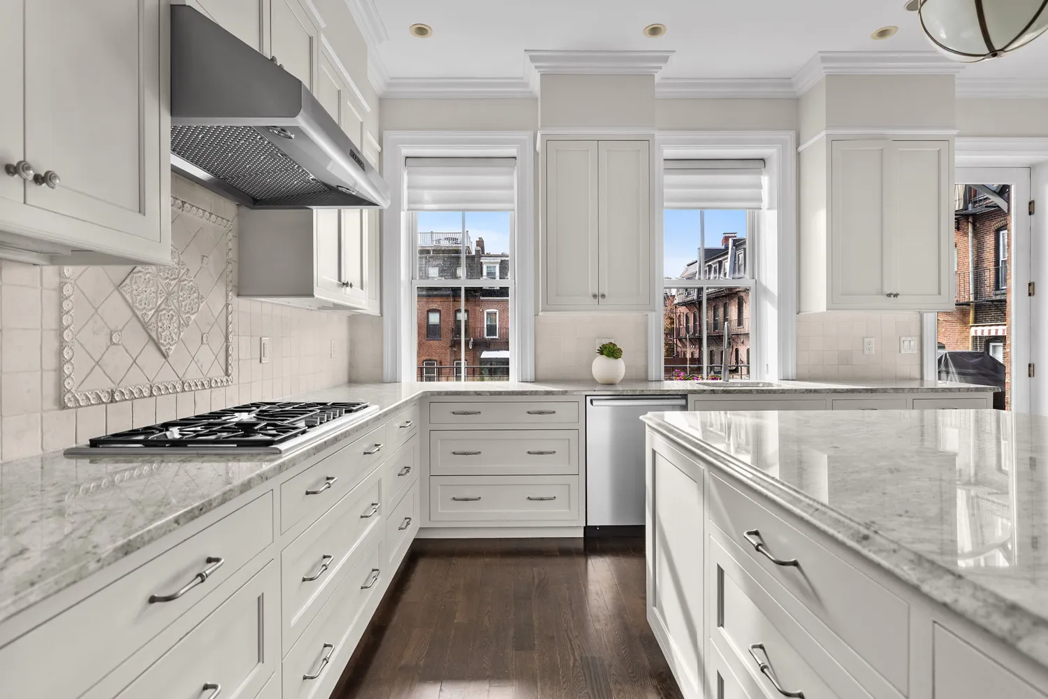 a kitchen with granite countertop a stove oven and white cabinets with wooden floor