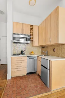 a kitchen with a stove a sink and a window