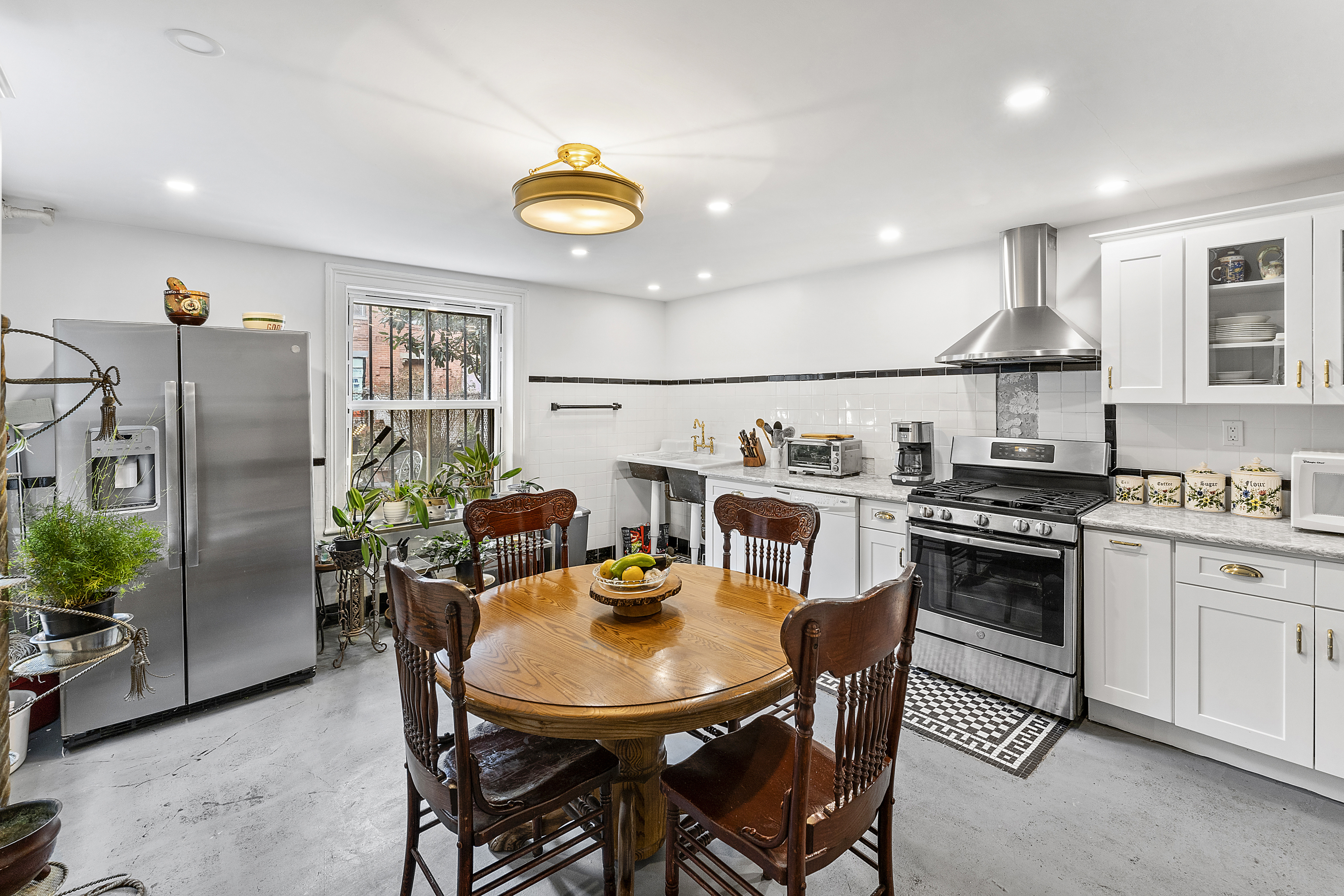 419 Clinton Avenue Brooklyn, NY 11238 - Photo 7 of 19 a kitchen with stainless steel appliances a dining table and chairs