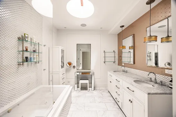 a spacious bathroom with a tub sink and mirror