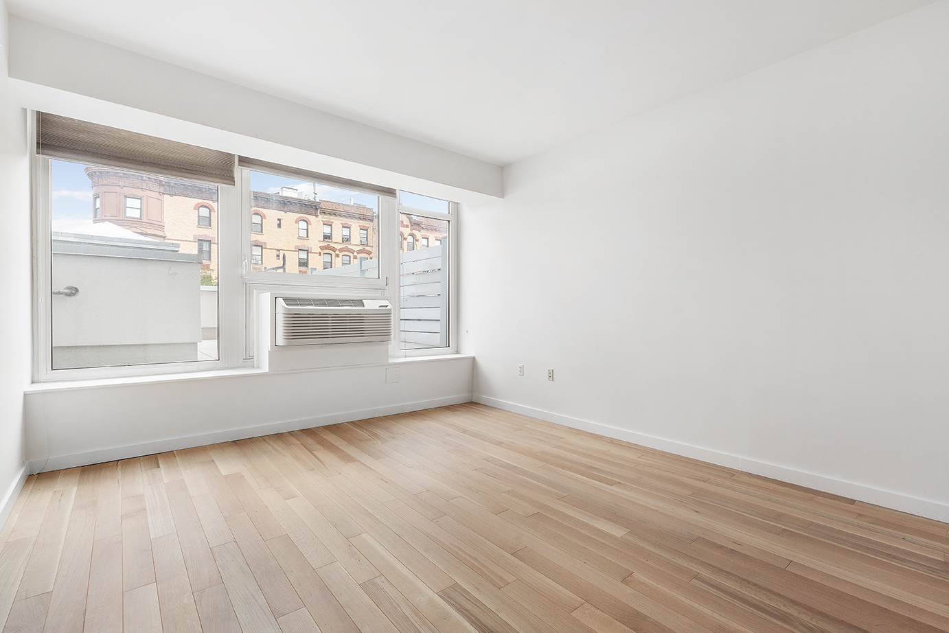 145 Park Place, Unit 3F Brooklyn, NY 11217 - Photo 4 of 9 an empty room with wooden floor and windows