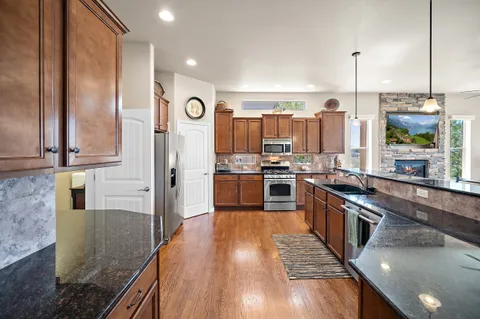 a kitchen with stainless steel appliances granite countertop a stove refrigerator and microwave