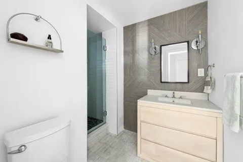 a bathroom with a sink a toilet and mirror