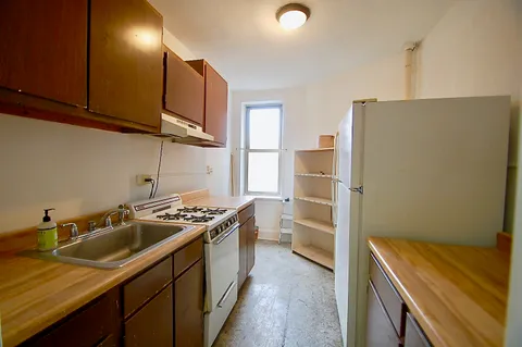 a kitchen that has a sink a stove and a refrigerator