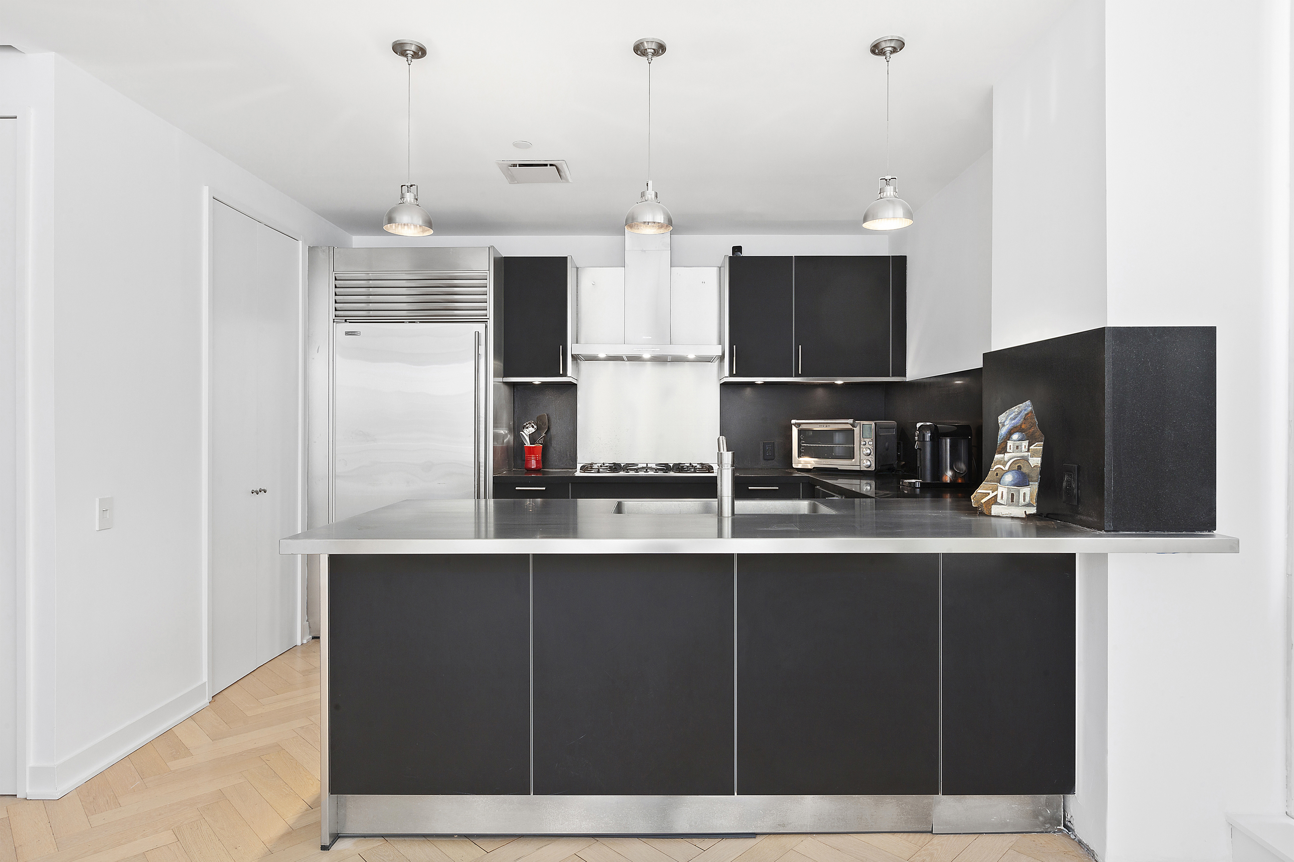 330 Spring Street, Unit 9C Manhattan, NY 10013 - Photo 2 of 8 a kitchen with stainless steel appliances a refrigerator and microwave