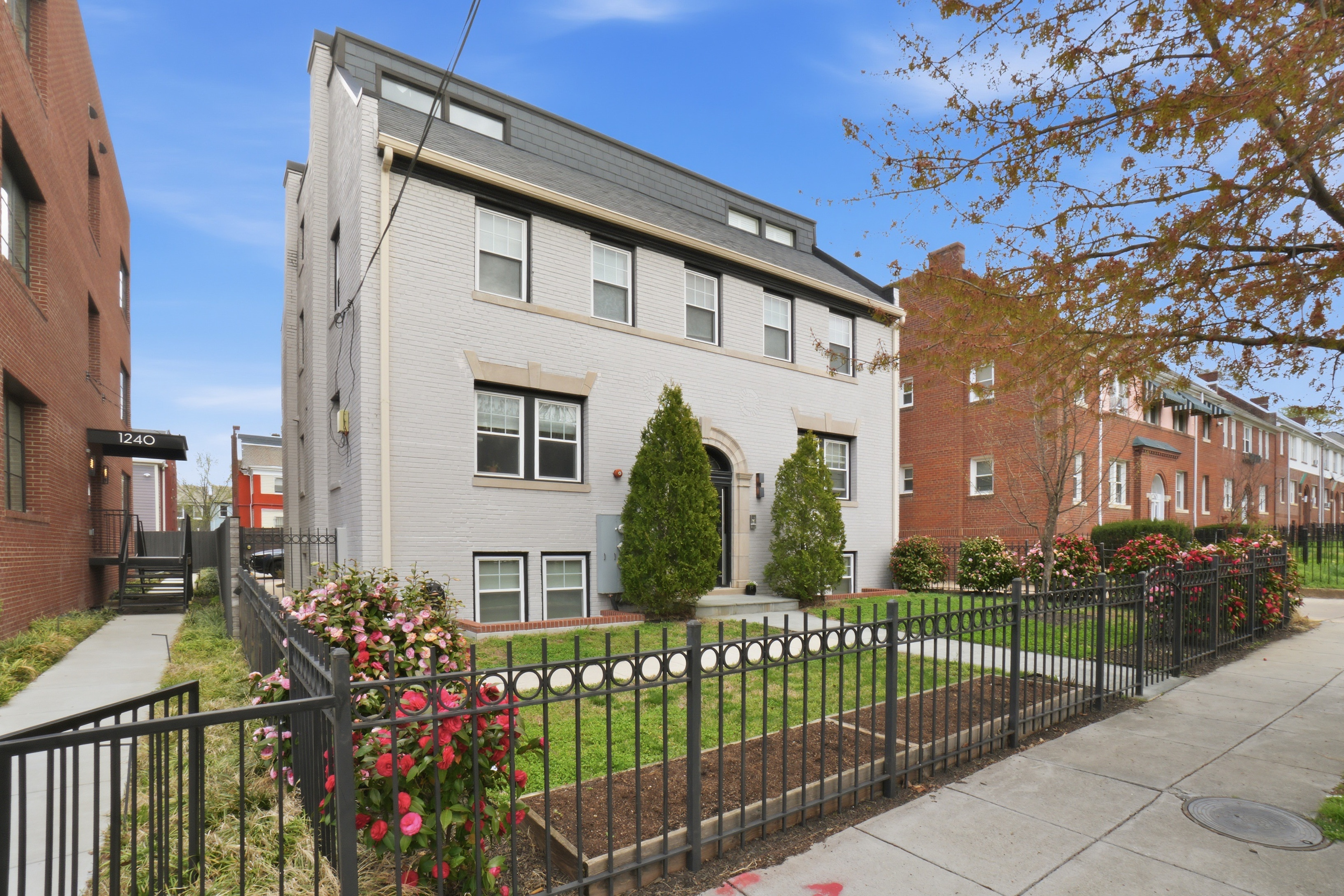 a view of a house with a small yard and wooden fence