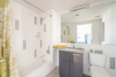 a bathroom with a granite countertop sink a toilet and shower