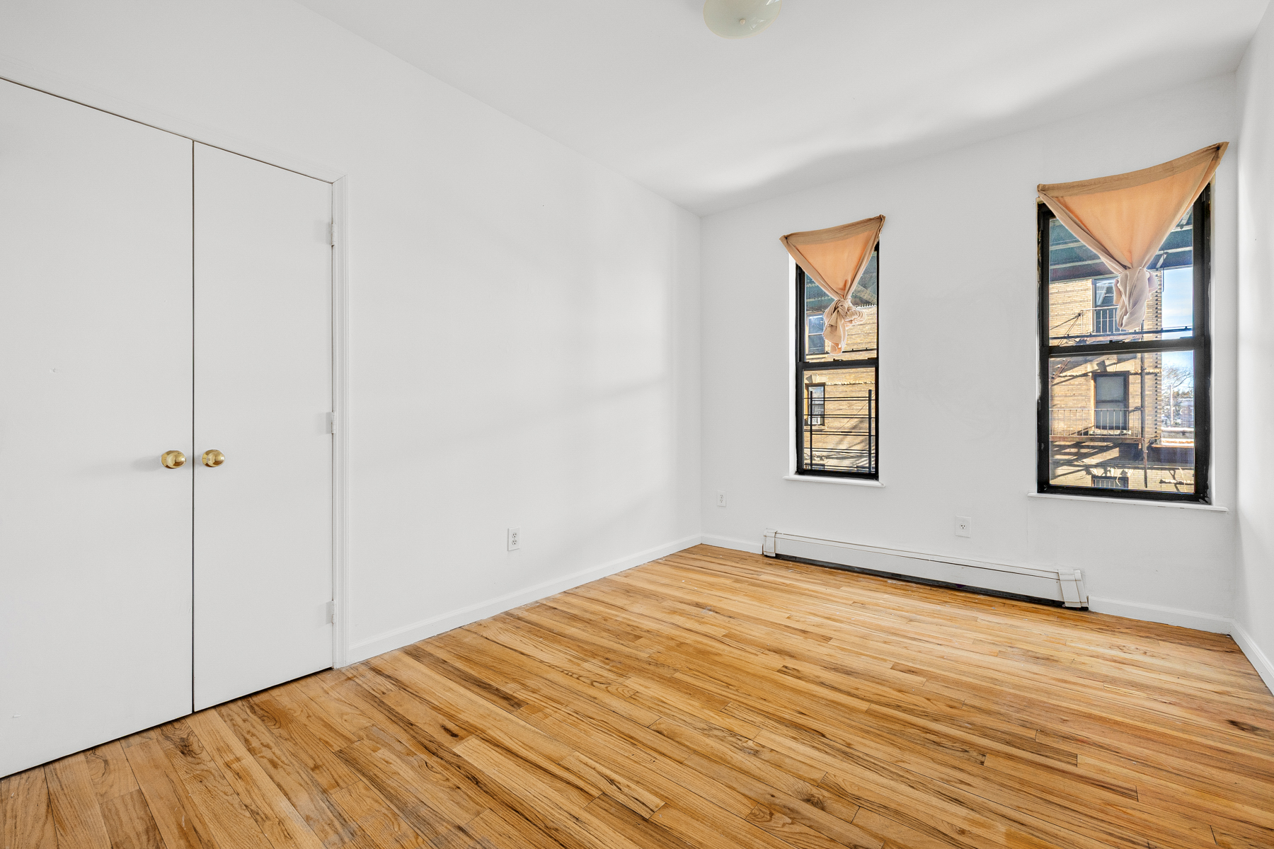 106 Crescent Street Brooklyn, NY 11208 - Photo 11 of 18 a view of an empty room with wooden floor and a window