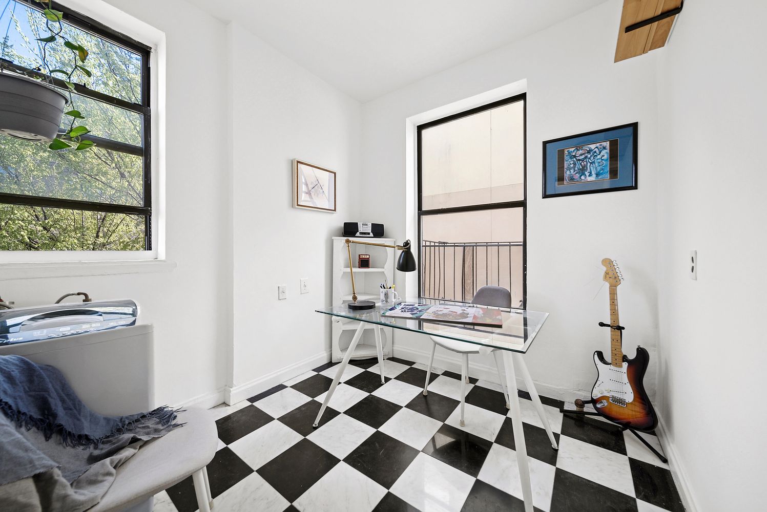 a room with a black white checkered floor with a gaming machine and a rug
