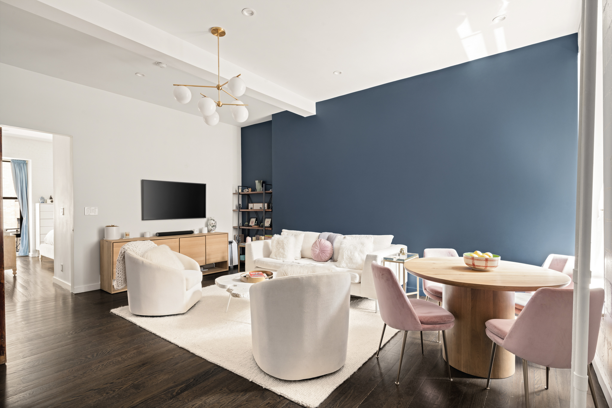 23 East 10th Street, Unit 508 Manhattan, NY 10003 - Photo 5 of 21 a living room with furniture a flat screen tv and a chandelier