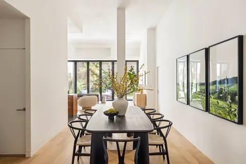 a view of a city from a dining room with furniture and window