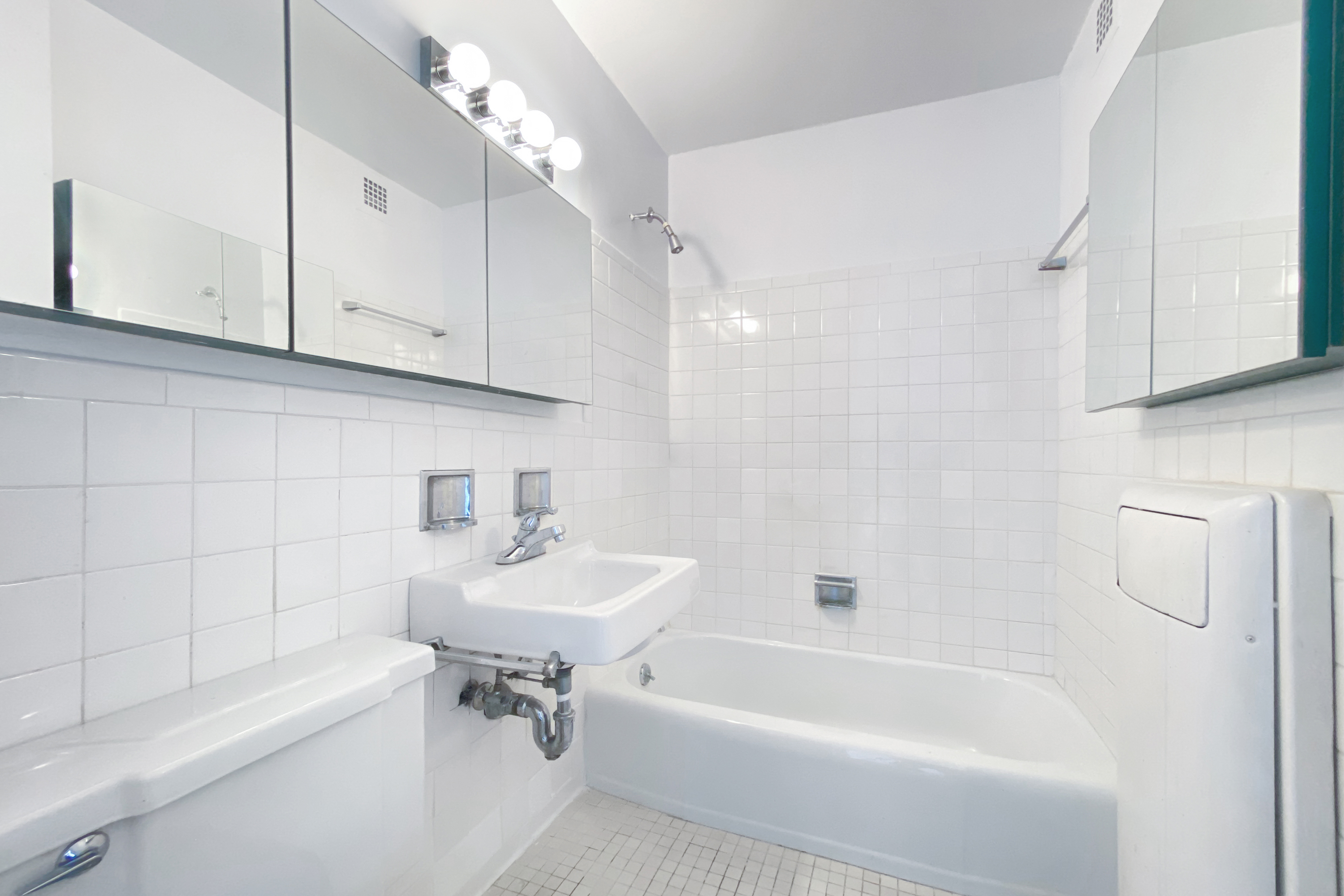 333 East 30th Street, Unit 16A Manhattan, NY 10016 - Photo 5 of 18 a white bath tub sitting next to a white sink and cabinets