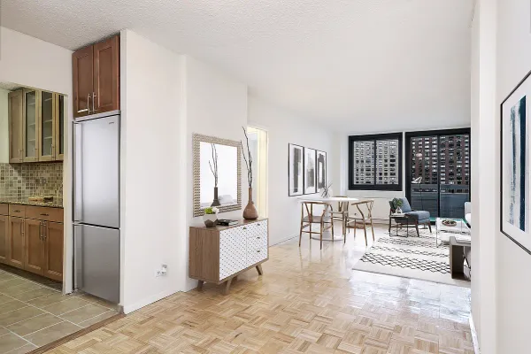 a living room with furniture a dining table and a refrigerator