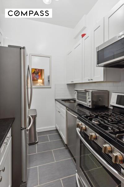 43 East 10th Street, Unit 5J Manhattan, NY 10003 - Photo 2 of 7 a kitchen with a stove and a refrigerator