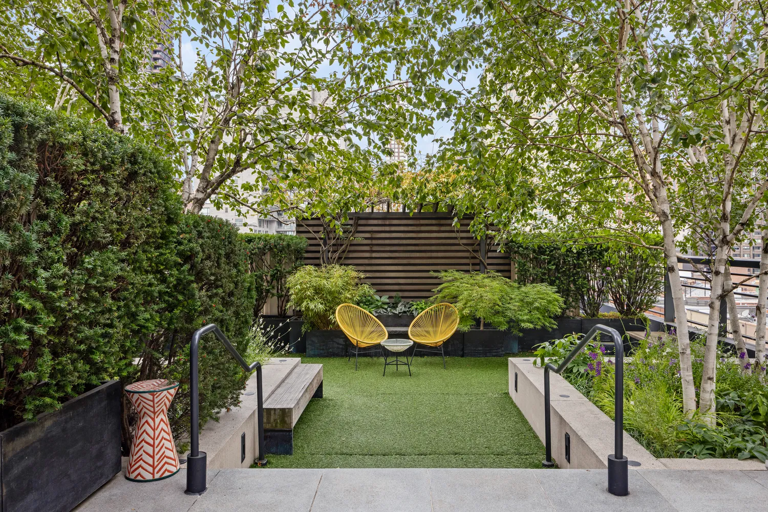 a view of a garden with plants and large trees