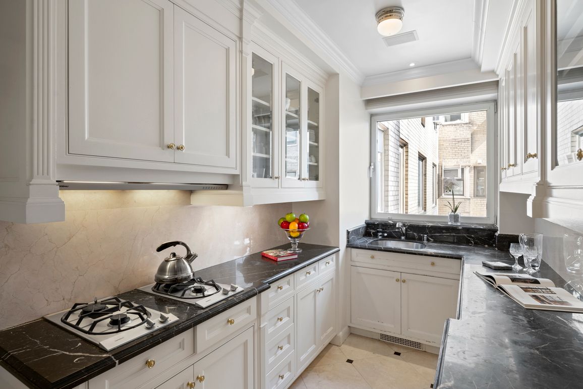 a kitchen with stainless steel appliances a sink a stove and cabinets