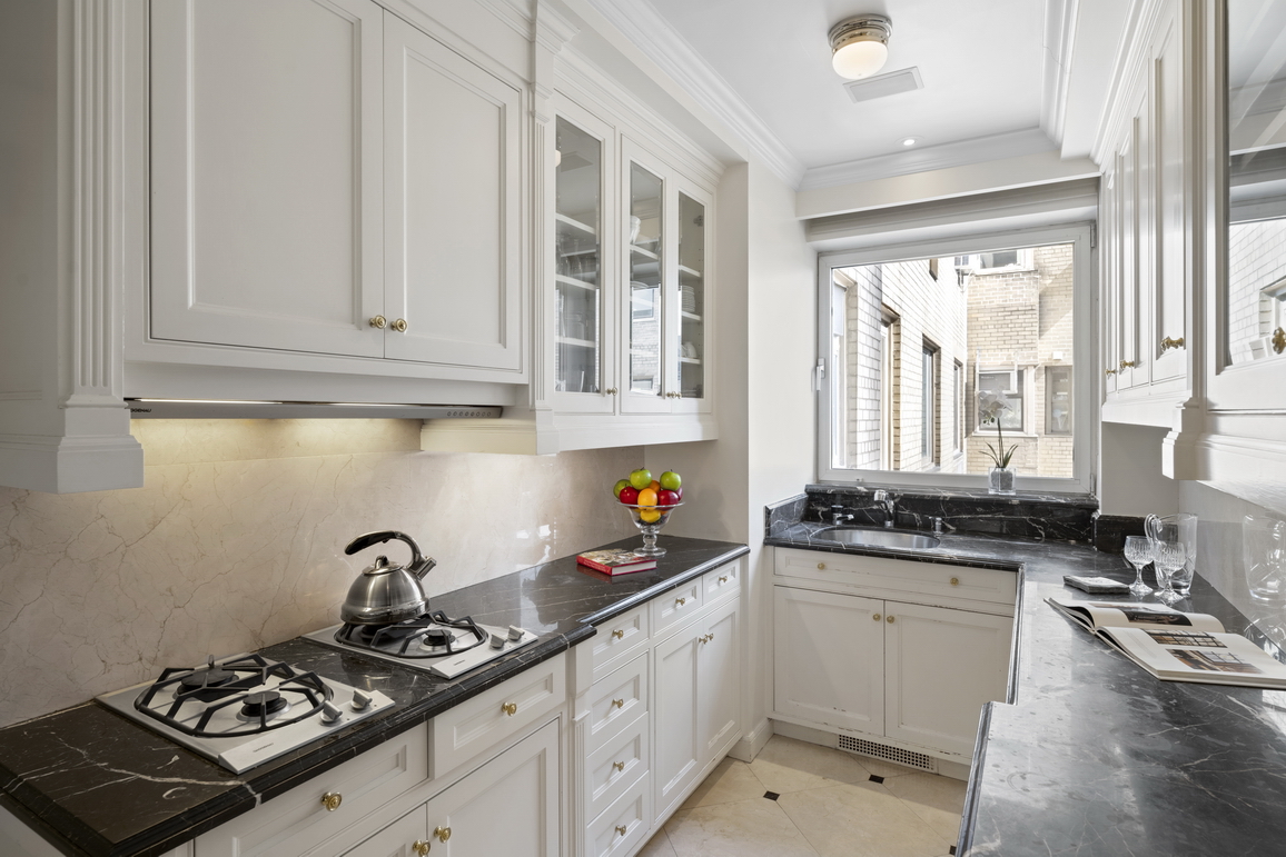 875 5th Avenue, Unit 18A Manhattan, NY 10065 - Photo 13 of 14 a kitchen with stainless steel appliances a sink a stove and cabinets