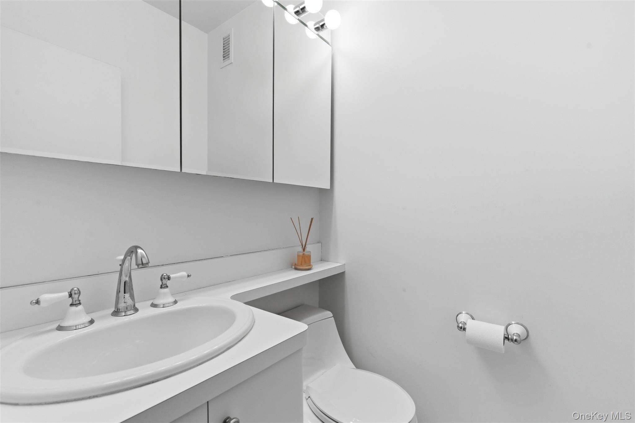27110 Grand Central Parkway, Unit 26A Queens, NY 11005 - Photo 8 of 30 a bathroom with a sink a toilet and mirror