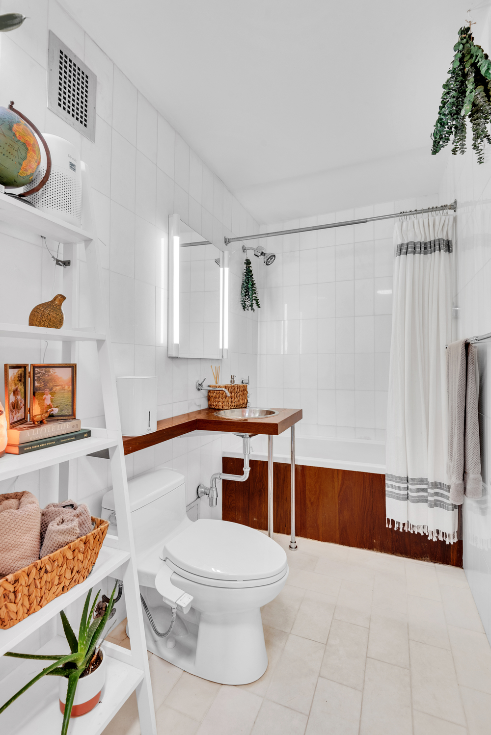 225 East 57th Street, Unit 14A Manhattan, NY 10022 - Photo 2 of 8 a bathroom with a sink a toilet and a shower curtain