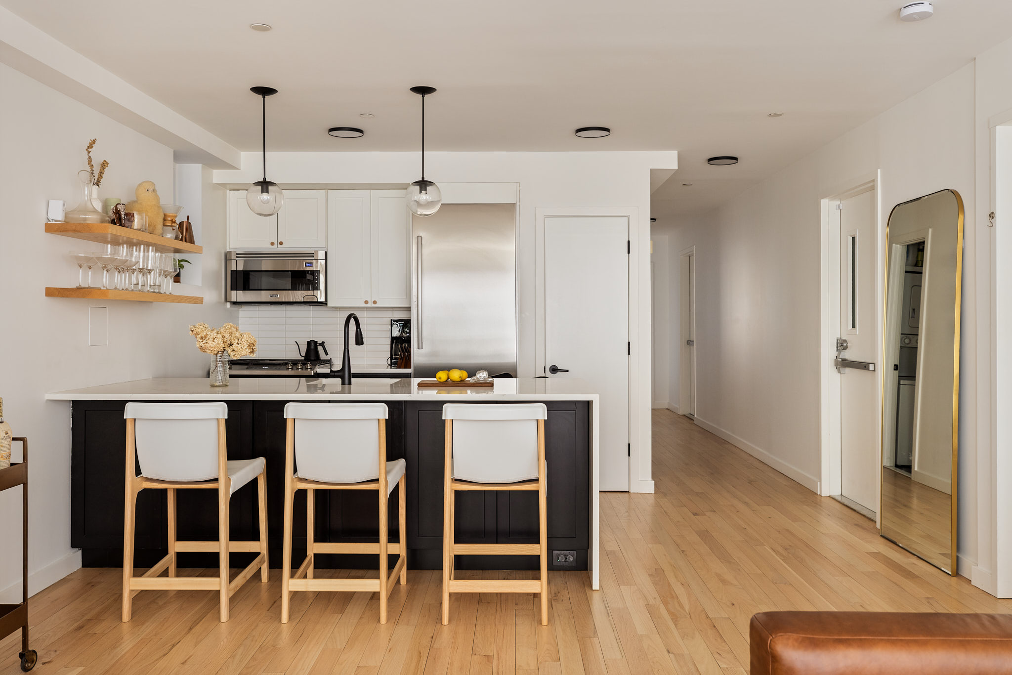 182 Mulberry Street, Unit 4 Manhattan, NY 10012 - Photo 6 of 13 a kitchen with stainless steel appliances granite countertop a table chairs refrigerator and microwave
