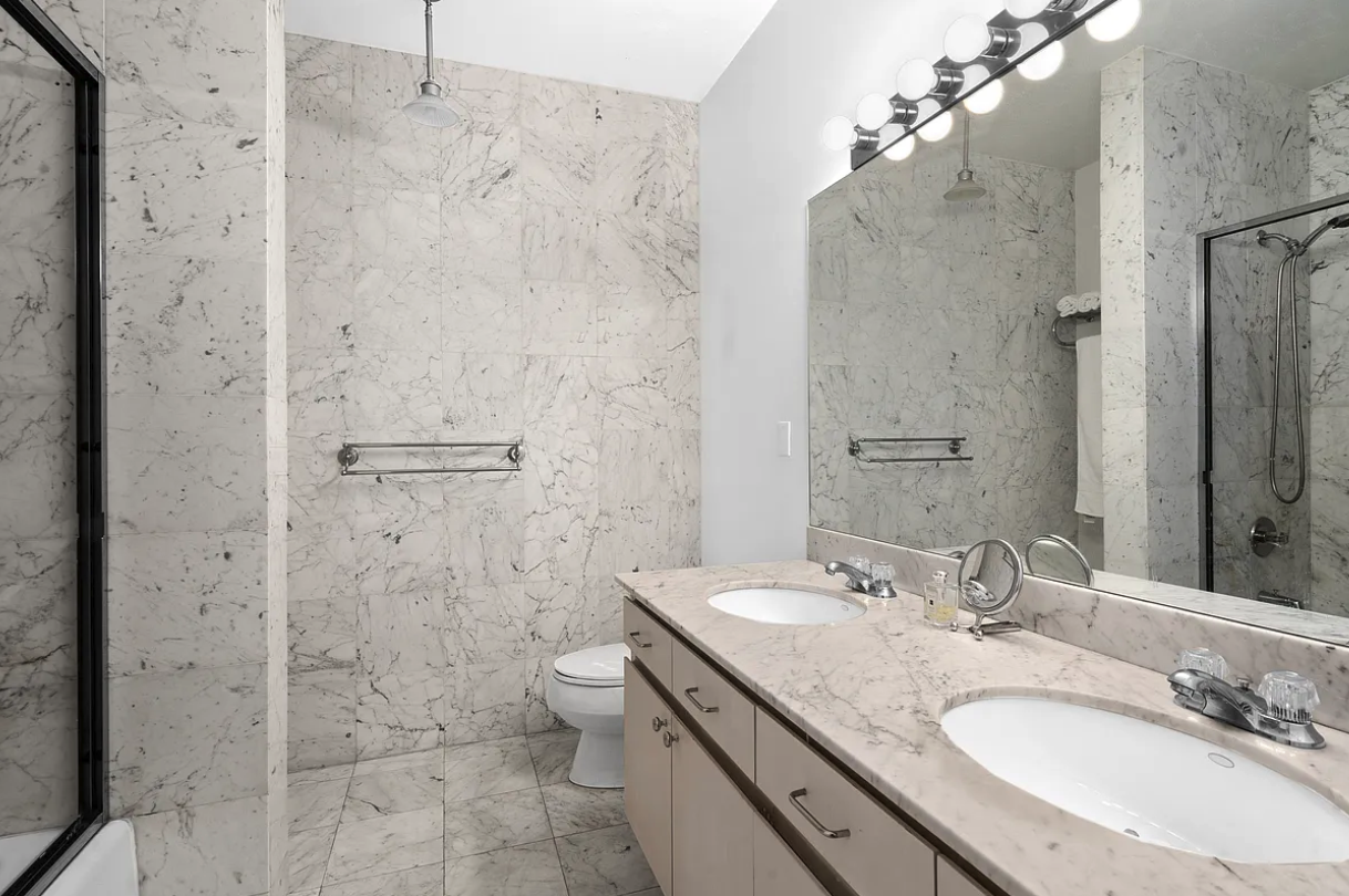 167 East 61st Street, Unit 21B Manhattan, NY 10065 - Photo 5 of 12 a bathroom with a granite countertop sink toilet and shower