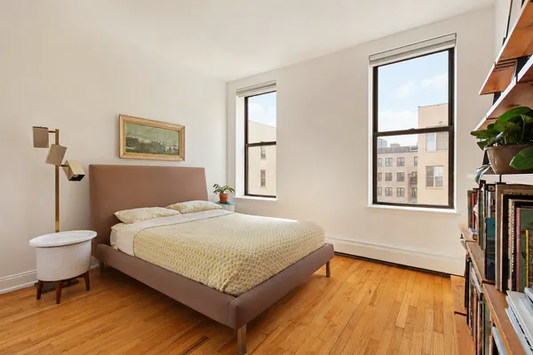 a bedroom with a bed and a large window