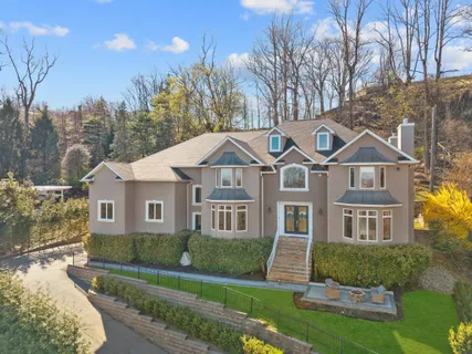 a front view of a house with a yard and trees