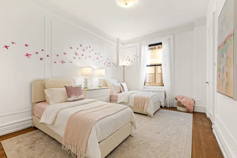 a bed room with two bed and a window