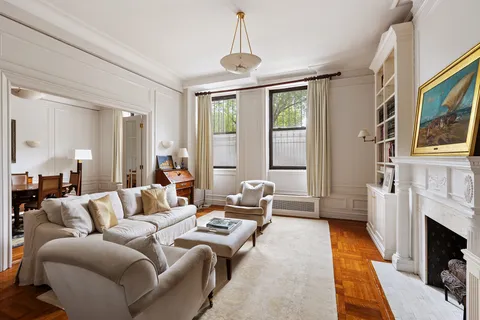 a living room with furniture a fireplace and a chandelier