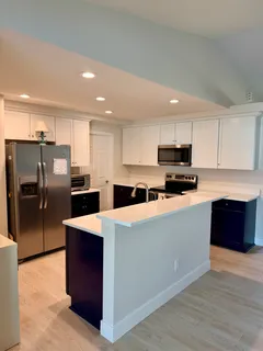 a large kitchen with stainless steel appliances and a refrigerator