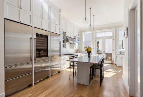 a living room with stainless steel appliances kitchen island granite countertop furniture and a wooden floor