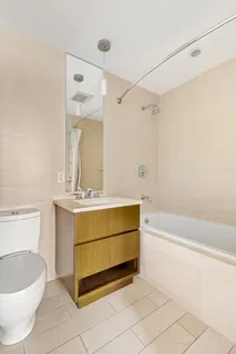 a bathroom with a granite countertop sink a toilet and bathtub