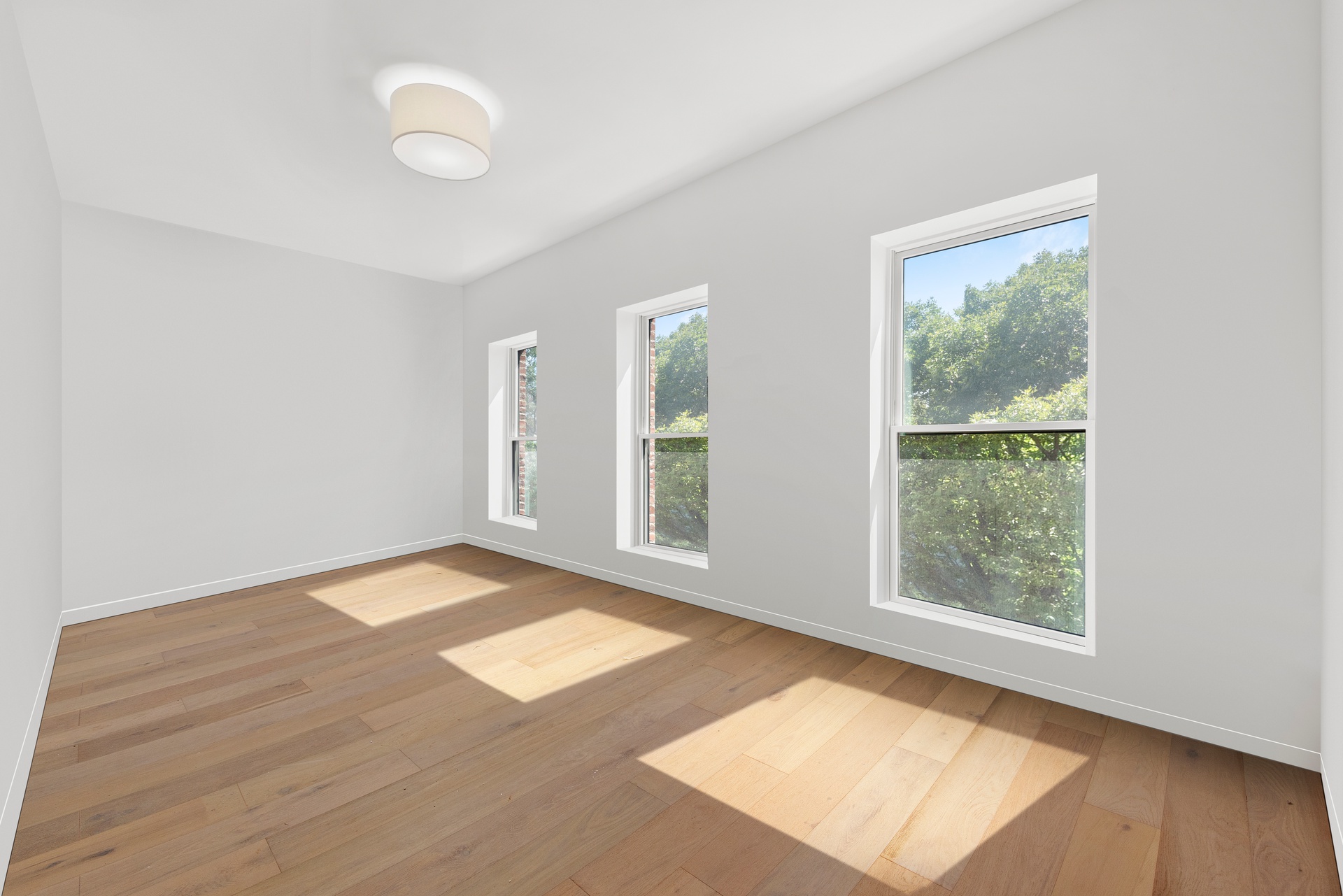 65 Bainbridge Street Brooklyn, NY 11233 - Photo 17 of 24 a view of an empty room with wooden floor and a window