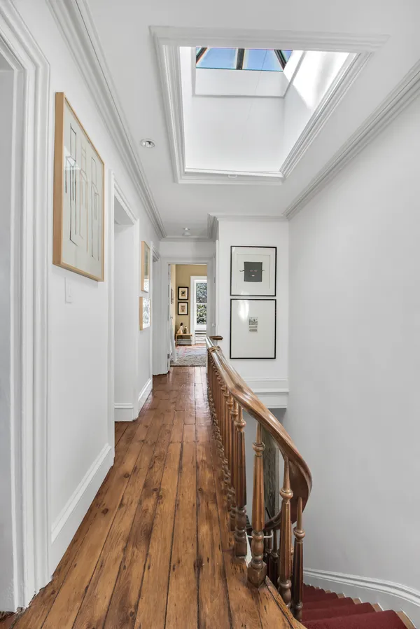 a view of a hallway with wooden floor and staircase