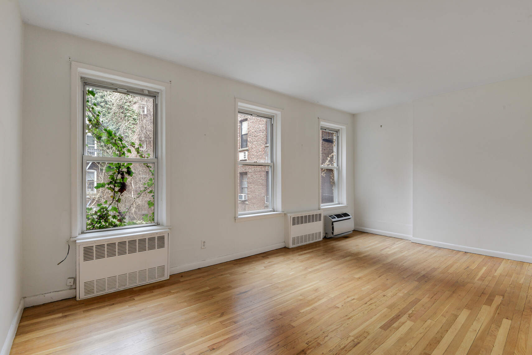 217 West 15th Street Manhattan, NY 10011 - Photo 20 of 21 a view of an empty room with wooden floor and a window