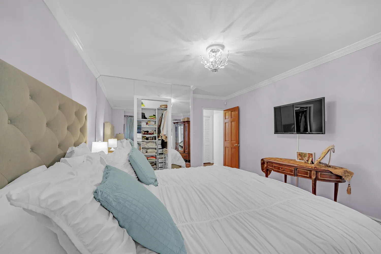 a bedroom with a bed and a chandelier