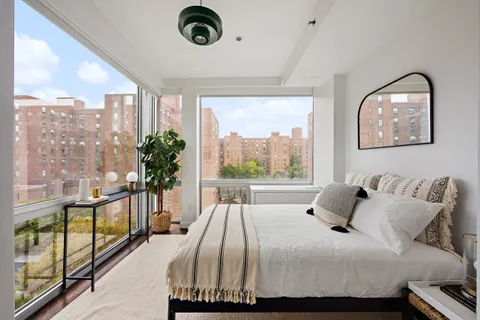 a bedroom with a bed and a large window