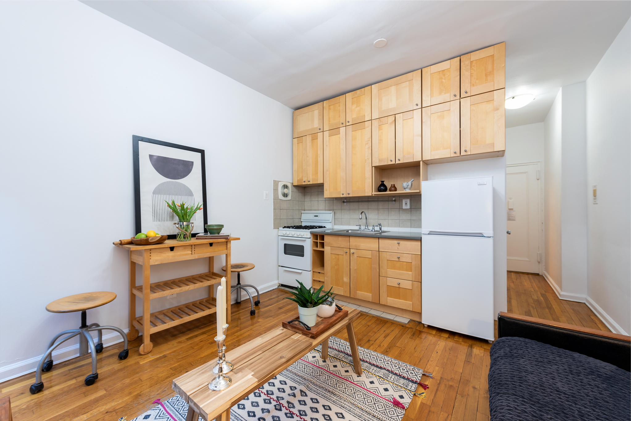 140 Claremont Avenue, Unit 2F Manhattan, NY 10027 - Photo 2 of 6 a kitchen with stainless steel appliances granite countertop a stove a sink and a refrigerator with wooden floor