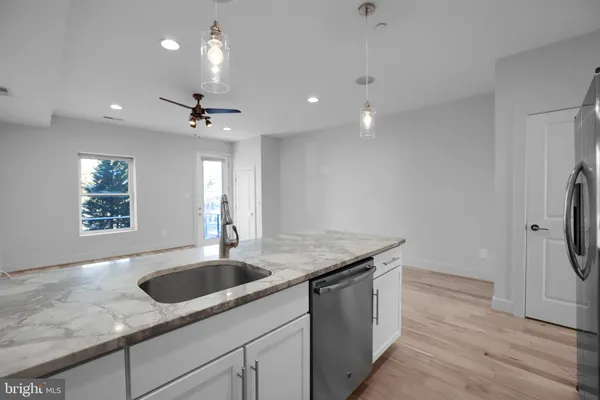 a kitchen with granite countertop a sink stainless steel appliances and chandelier