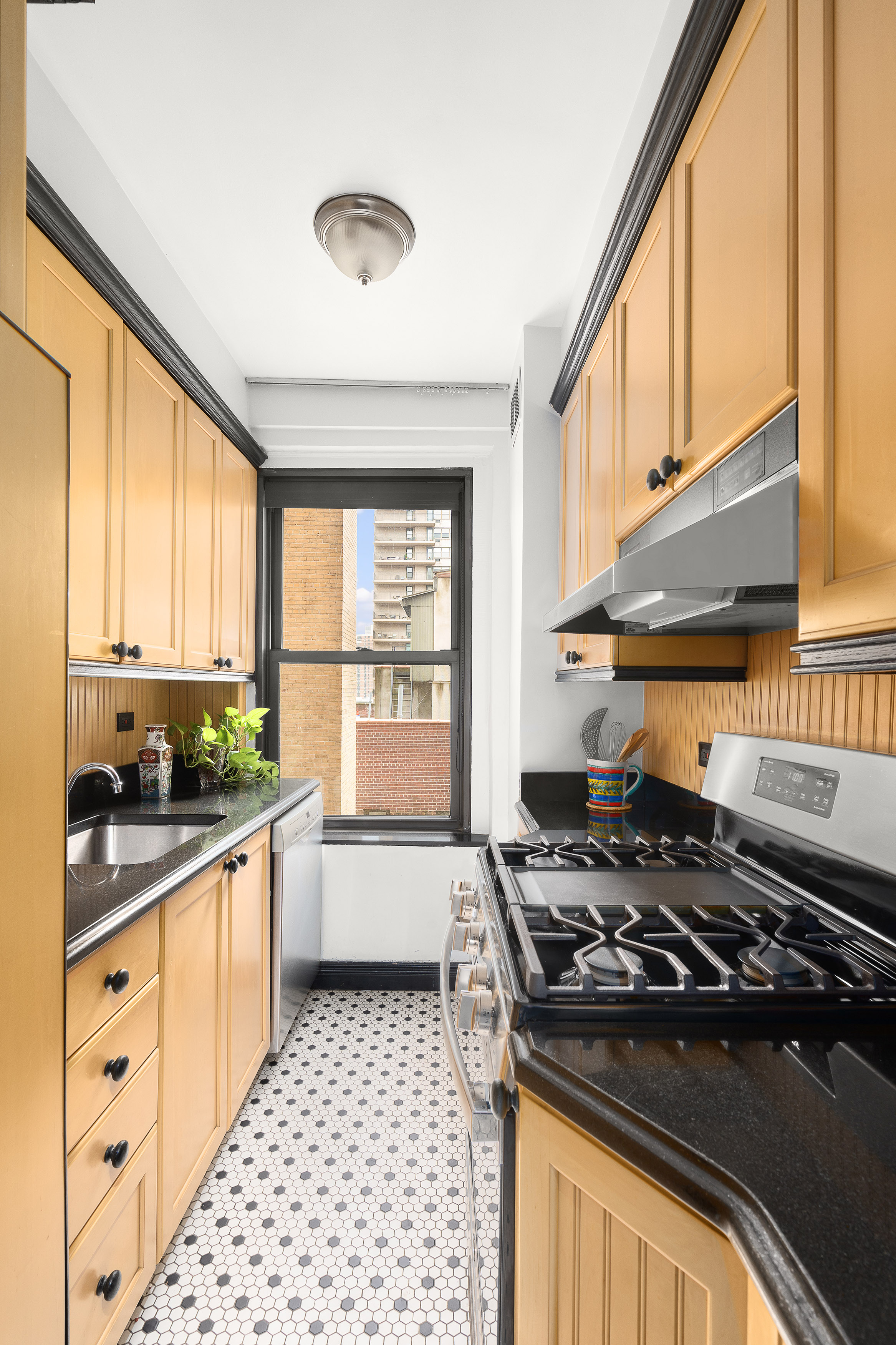 235 West End Avenue, Unit 8D Manhattan, NY 10023 - Photo 6 of 11 a kitchen with a stove a sink and a window