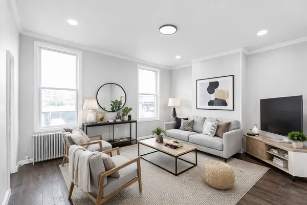 a living room with furniture a flat screen tv and a window