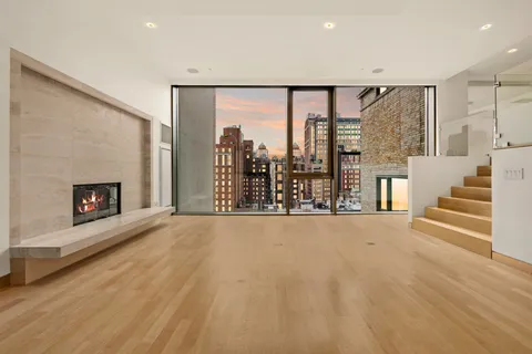 an empty room with windows and fireplace