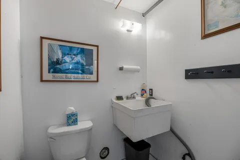 a bathroom with a sink mirror and toilet