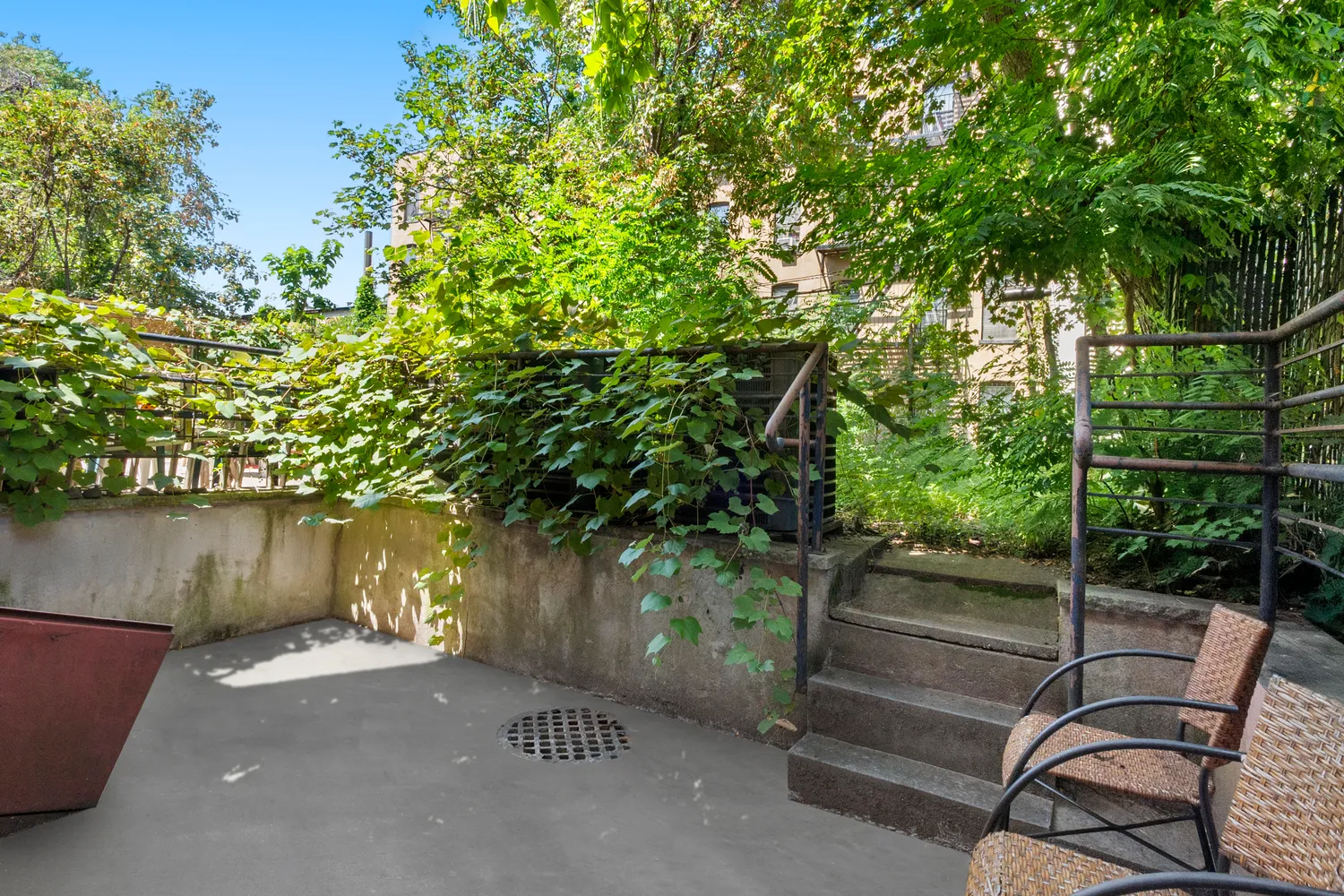 a patio with table and chairs and potted plants