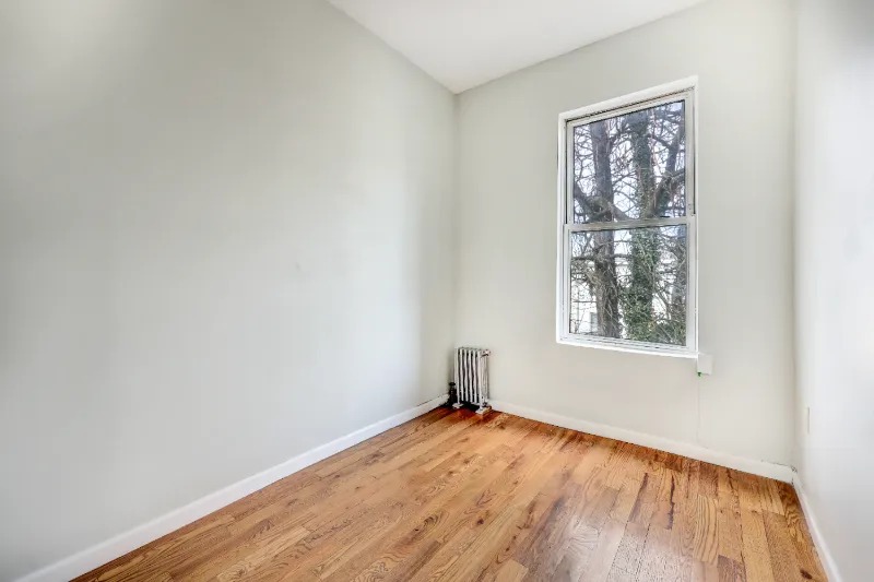 255 Covert Street Brooklyn, NY 11207 - Photo 8 of 18 an empty room with wooden floor and windows