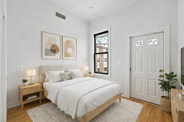 a bedroom with a bed and a potted plant
