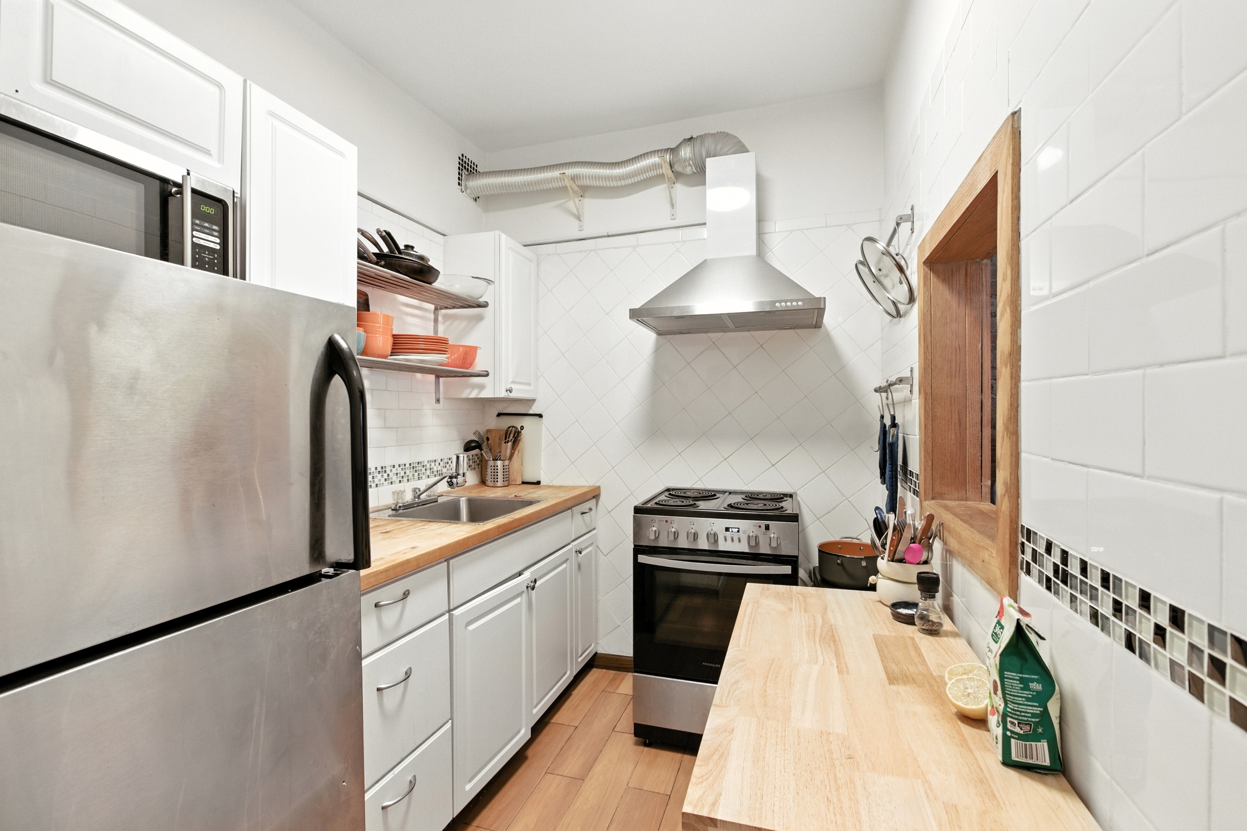 522 East 88th Street, Unit 4A Manhattan, NY 10128 - Photo 2 of 5 a kitchen with stainless steel appliances a sink a stove and a refrigerator
