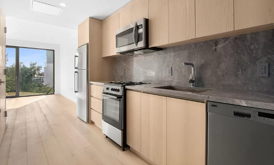 567 Ocean Avenue, Unit A607 Brooklyn, NY 11226 - Photo 3 of 12 a kitchen with stainless steel appliances a sink dishwasher stove refrigerator and microwave